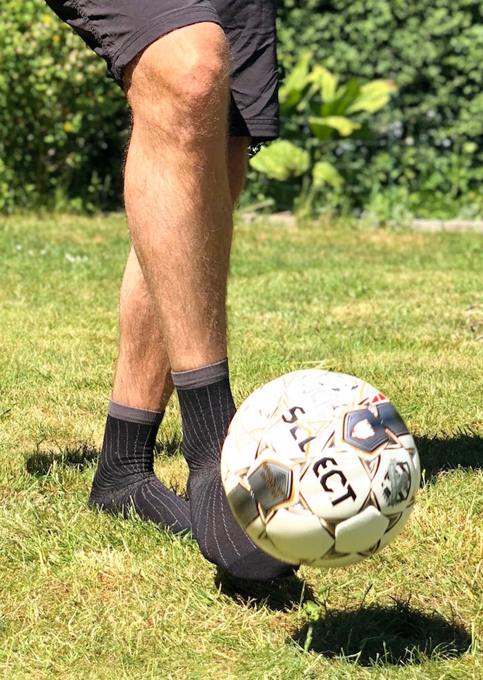 Svart sportkompressionsstrumpa på fot